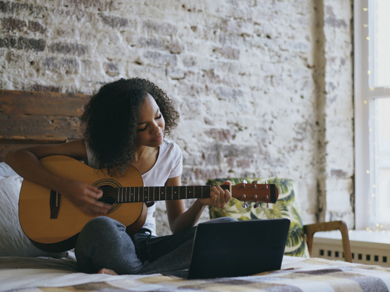 A woman taking an online guitar lesson