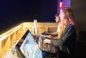 Live audio engineer operating a front of house mixing console during a concert performance