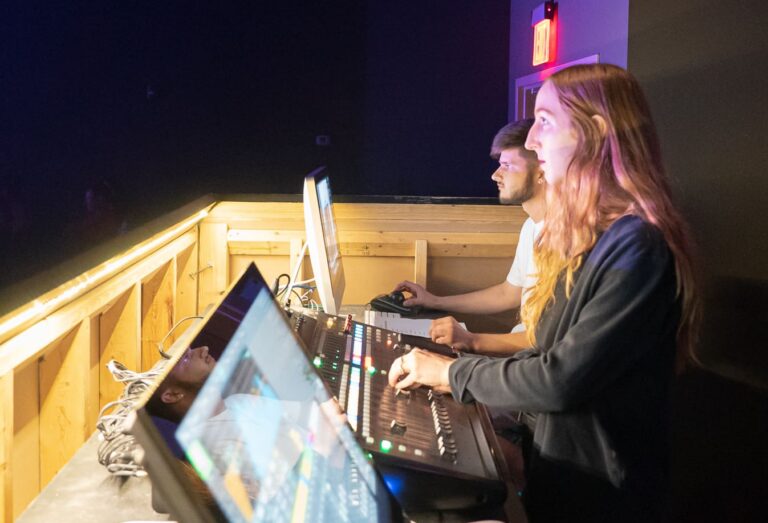 Live audio engineer operating a front of house mixing console during a concert performance